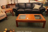 Solid pine coffee table with two glass panels and wooden center, placed in a room with a black leather couch and carpet.