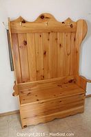 Front view of solid pine hall bench showing hinged seat and back panel with hooks