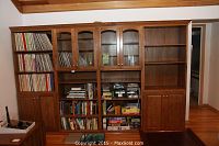 Full front view of oak bookcase loaded with books and games (contents not included)