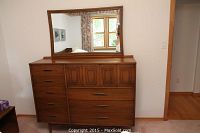 Front view of walnut-tone dresser with mirror attached