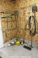 Wide view showing corner with various garden tools and small pots on floor