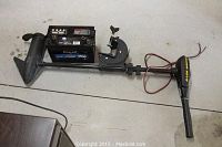 Full view of Minn Kota electric trolling motor with attached Select Xtras battery lying on floor.