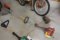 Full length view of orange and grey edger with guide wheel on concrete floor