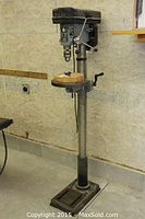 Front view of floor-standing drill press showing base, column, table and head