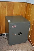 Safe in corner of room on carpet with combination dial visible