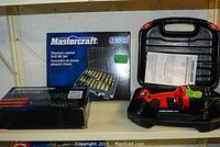 Shelf display of three main items: Black & Decker drill in case, Mastercraft screwdriver set, Mastercraft drill bit set box.