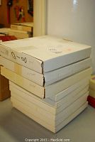 Stack of nine white boxes containing the collector plates, some labeled by name such as Automie and Hiver.