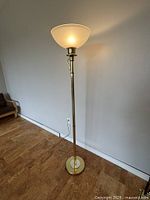 Full view of brass torchiere floor lamp standing in room
