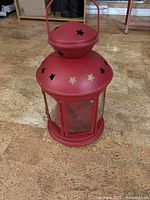 Full view of red IKEA lantern showing star cutouts and handle