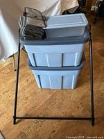 Stacked Rubbermaid totes with small tote, magazine holders, garment rack frame