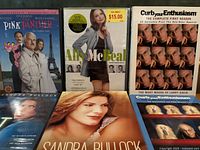 Front covers of The Pink Panther, Ally McBeal, Curb Your Enthusiasm, two Sandra Bullock DVDs