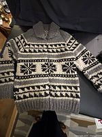 Front view of grey, black and white geometric wool sweater