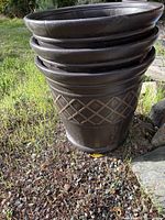 Three stacked dark resin planters with lattice pattern