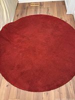 Full view of round red rug on floor