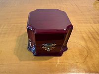 Front view of burgundy wooden ring box with latch closed