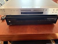 Sony CD/DVD player stacked on Motorola HD DVR, frontal view shows logos and disc tray