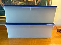 Stack of two white translucent rectangular Tupperware containers with blue lids