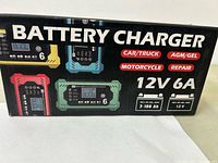 Box showing product details including compatibility (car/truck, AGM/GEL, motorcycle), 12V 6A output, and battery capacity range.