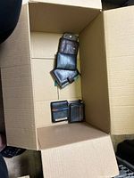 Box with several wallets arranged in a row showing various closures and worn conditions.