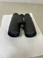 Front view of the Bushnell binoculars showing dual objective lenses and central focusing knob.
