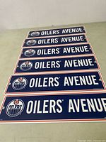 Front view of all six Edmonton Oilers Oilers Avenue street signs laid out flat showing branding and text.