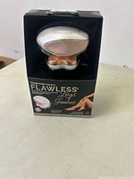 Photo of the Finishing Touch Flawless Legs rechargeable hair remover in packaging showing product shape and colors