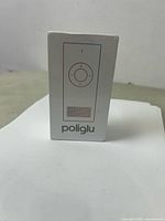 Front view of the sealed Poliglu box showing simple icon-based design and brand name.