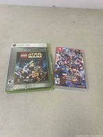 Photo showing both LEGO Star Wars: The Complete Saga for Xbox 360 and Marvel vs Capcom Fighting Collection for Nintendo Switch games sealed and unopened.