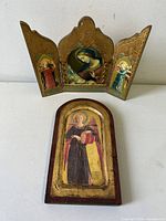 Front view of both pieces: the folded triptych and the arch-shaped angel panel