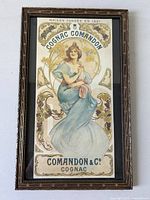 Framed vintage Art Nouveau poster showing woman and grapevine motifs with brand name Comandon & Co Cognac in gilt detailed frame