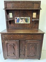 Full front view of the child-sized primitive Welsh dresser showing carved Catail Cross and geometric motifs, central rectangular mirror, small side mirrors above shelves, drawer, and cabinet doors.