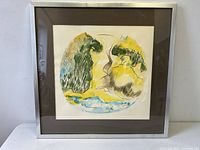 Frontal view of the framed abstract watercolour painting with circular design in green, yellow, blue, and black.