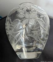 Close-up of the glass vase showing detailed strawberry plant etching with leaves and berries visible.