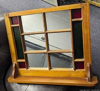 Front view of pine wood mirrored window frame with stained glass accents and wooden base stand.
