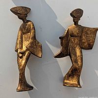 Front view of both gold and black patina cast iron Geisha dancer figurines showing the poses and size.