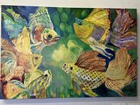Frontal photo of the very large mixed media canvas print depicting tropical fish in a green underwater setting. Shows the signature of the artist Phyllis Knight in bottom right corner.