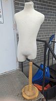 Front side of the fabric-covered torso mounted on wooden base showing overall condition.