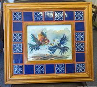 The full wood framed watercolor painting with blue and white tile border is shown.