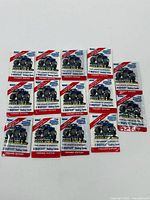 Fourteen sealed packs of Bigfoot Monster Truck trading cards displayed together.