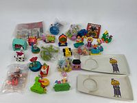 Photo showing a group of 29 McDonald's kids meal toys including character figurines and small playsets displayed on a white surface.