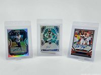 Group photo of three signed football cards in protective sleeves featuring Laremy Tunsil, D.J. Moore, and Diontae Johnson