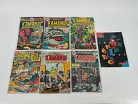 Seven Kamandi comic books laid out in two rows showing various vivid cover illustrations including action scenes with animals, humans, and post-apocalyptic themes.
