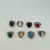 Full group of 8 sterling silver rings with various colored stones arranged in two rows.