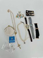 Full view of assortment including necklaces, earrings, coin purse, watches and pin.