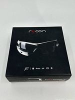 Original retail box of Recon Instruments JET Smart Glasses showing branding and icons for Bluetooth, WiFi, GPS, and ECompass.