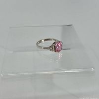 Front angle showing band and pink center gemstone with clear side stones