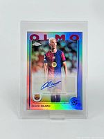 Front of the holographic Topps Chrome Dani Olmo card with visible autograph in blue ink and player image in FC Barcelona kit.
