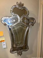 Full front view of the Venetian shield wall mirror hanging on wall, showing ornate crystal floral adornments and large etched side panels.
