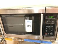 Front view of Farberware microwave on metal shelf with digital control panel and display showing 0:59 time.