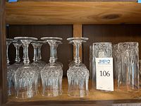 Side view of 8 upside-down wine glasses with geometric cut pattern and 4 tumblers showing the geometric cut pattern also.